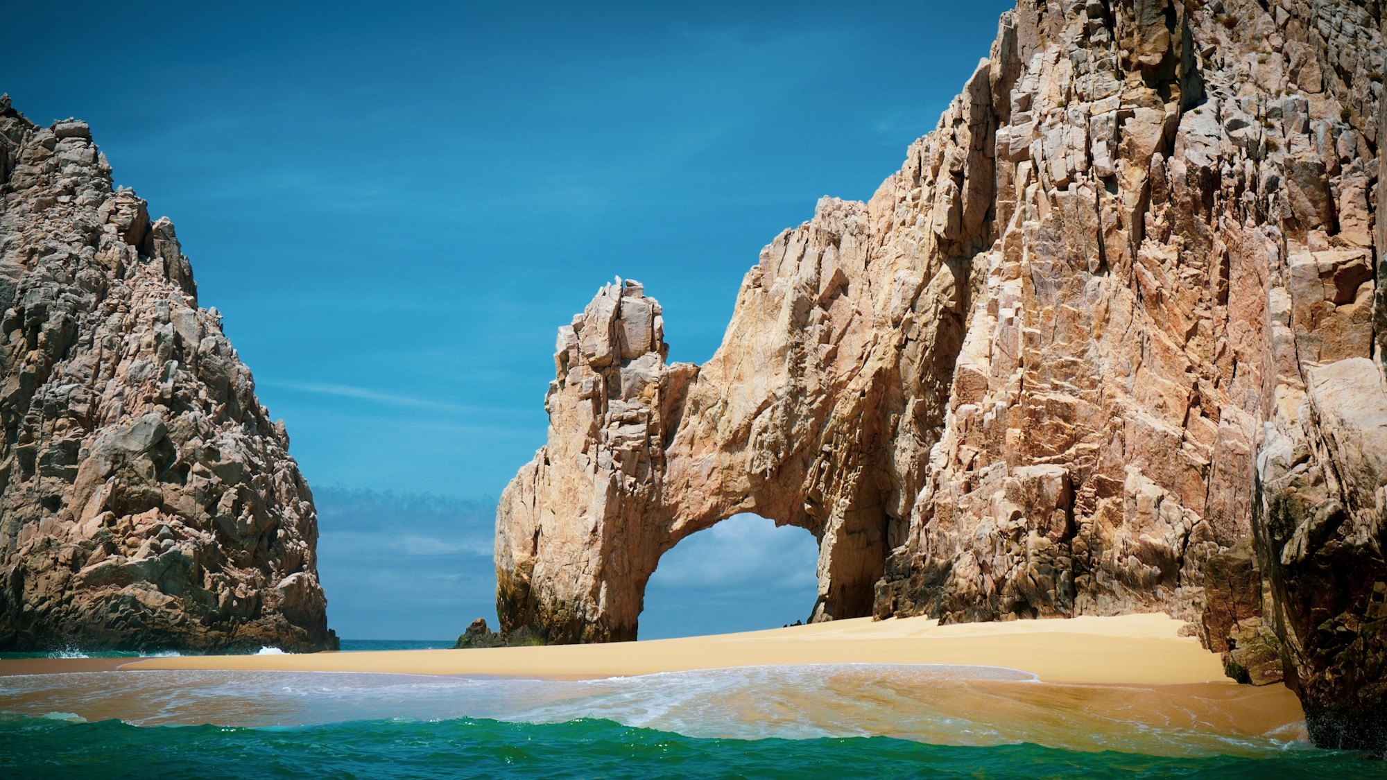 El Arco’s natural rock arch above golden sand and turquoise water in Cabo San Lucas
